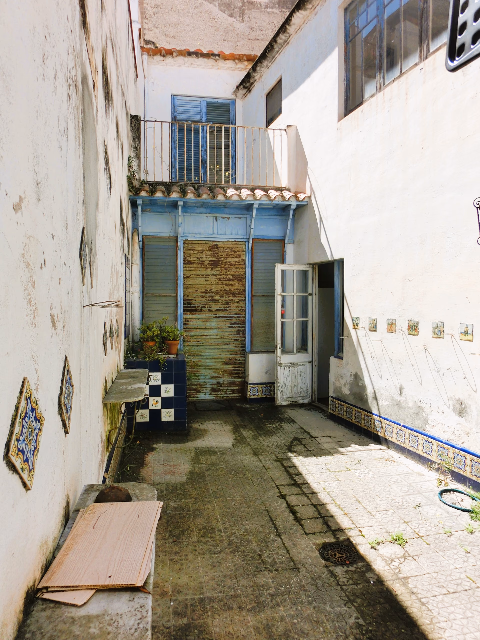 Pati interior i façana amb persianes de fusta d’una casa de poble de 1890 a Canet de Mar